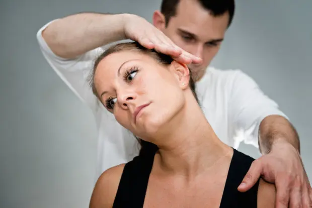 Woman that is receiving a chiropractic adjustment from a chiropractor.