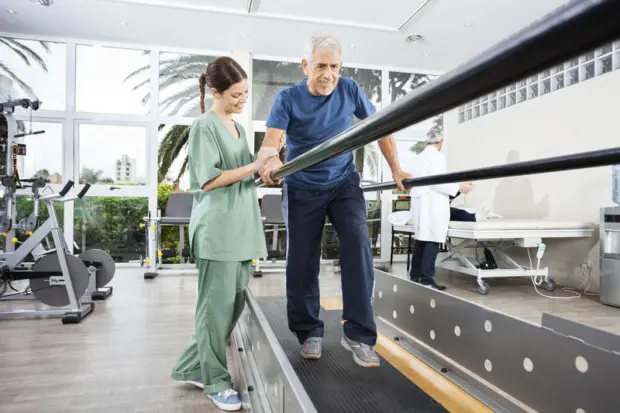 A physical therapist helping a patient with their rehabilitative therapy.